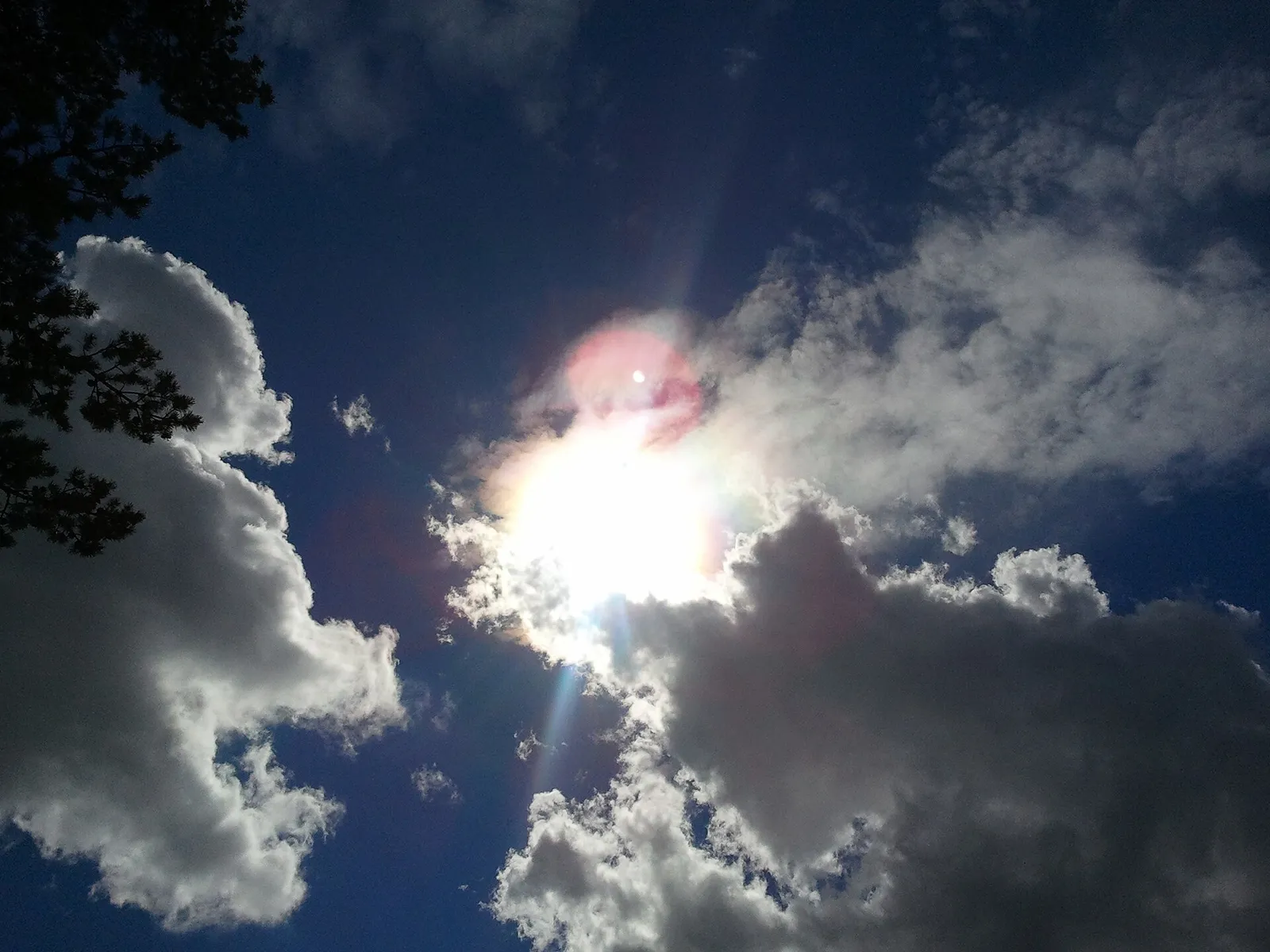 Aurinkoa ja pilviä kesätaivaalla (kuvituskuva)