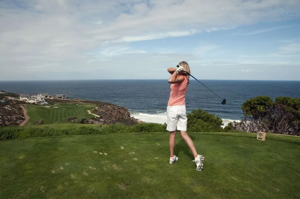 Golfaaja lyöntiliikkeen päätteessä kentällä